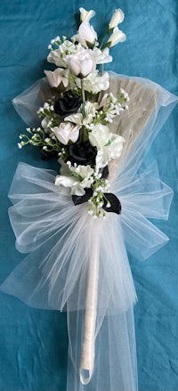 a fan with black and white flowers and tulle