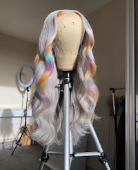 a wig with rainbow colored hair on a tripod