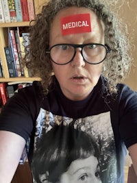 a woman wearing glasses and a t - shirt with a picture of a woman on it
