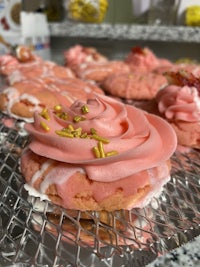 a tray of pink frosted cookies on a tray