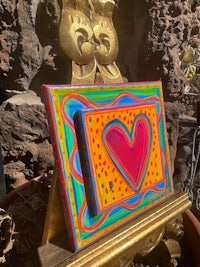 a painting of a heart on a gold stand