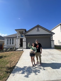 two people standing in front of a house