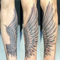 a tattoo of an angel wing on the forearm