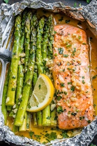 salmon and asparagus in foil packets with lemon wedges