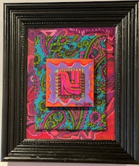 a framed piece of art with a colorful paisley pattern
