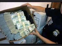 a police officer is holding a box full of money