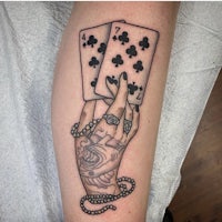 a tattoo of playing cards on a person's leg