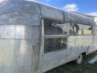 an airstream trailer is parked in a field