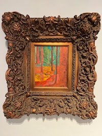 a painting of a forest in an ornate frame