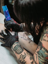 a woman getting a tattoo in a tattoo parlor