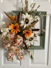 a fall wreath hanging on a door