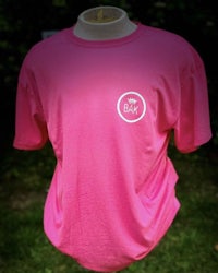 a pink t - shirt with a white logo on it