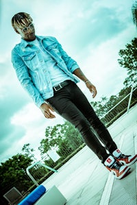 a man in a blue jacket standing on a roof