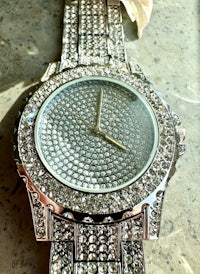 a silver watch with rhinestones on it