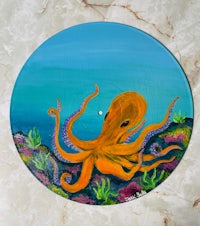 an orange octopus is painted on a round plate