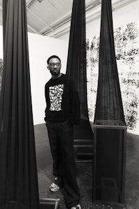 a man standing in front of a black and white curtain