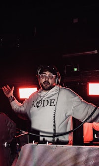 a man with headphones in front of a dj booth