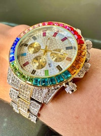 a person's wrist with a rainbow colored watch on it