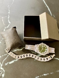 a box with a watch and a bracelet next to it