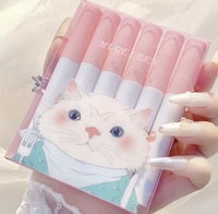 a hand holding a pink box with a cat on it