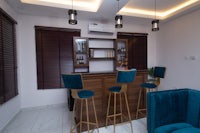 a living room with blue chairs and a bar