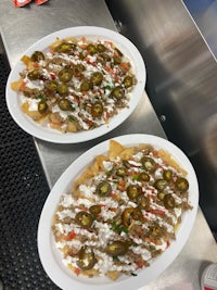 two plates of nachos on a counter