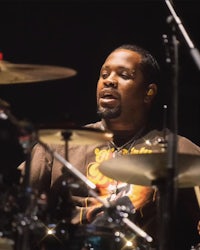 a man playing drums in front of a microphone