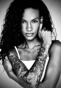 a black and white photo of a woman with tattoos
