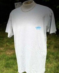 a white t - shirt with a blue crown on it
