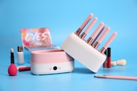 a set of makeup brushes and cosmetics on a blue background
