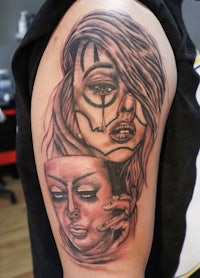 a tattoo of a woman with a mask on her arm