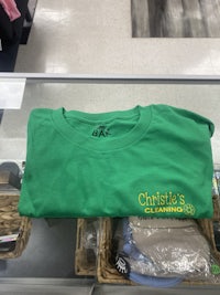 a green t - shirt is on display in a store