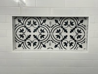 a black and white tiled shower with a black and white pattern