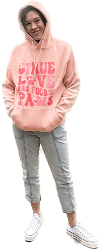 a woman wearing a pink hoodie and jeans