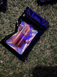 a bag of lipsticks and a bag of lipsticks laying on the grass