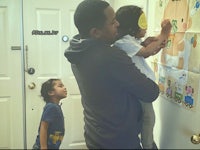 a man and his two children looking at a poster