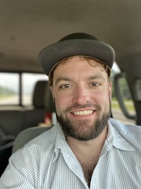 a man smiling in the back seat of a car