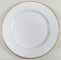 a white plate with gold rim on a white surface