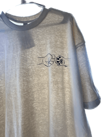 a beige t - shirt with a paw print on it
