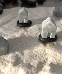 a set of small marble houses on a piece of sand