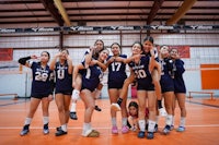 a group of volleyball players posing for a picture