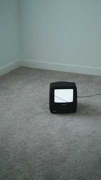 a tv sitting on a carpeted floor