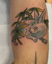 a tattoo of a rabbit with bamboo leaves