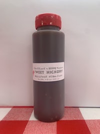 a bottle of barbecue sauce on a red and white checkered tablecloth
