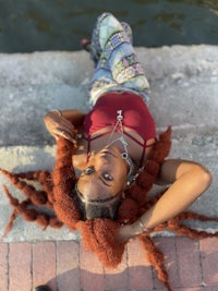 a woman laying on the ground with dreadlocks