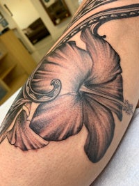 a tattoo of a flower on a person's arm