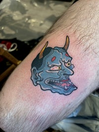 a tattoo of a demon on a man's leg