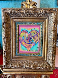 a gold frame with a painting of a heart