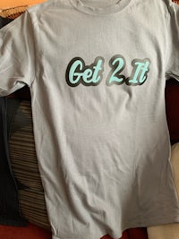 a grey t - shirt with the word get 2 it on it
