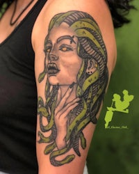 a tattoo of a woman with snakes on her arm